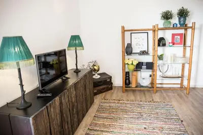 a living room with a tv and a table with a lamp at Apartment Serrão in Funchal