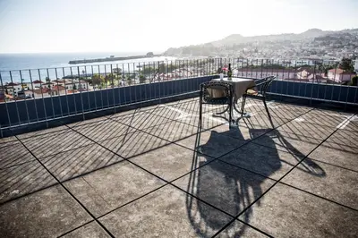 a table and chair on a balcony with a view of the ocean at Apt. Downtown 2 in Funchal