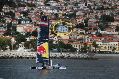 a sail boat in the water in front of a city at Apt. Downtown 2 in Funchal