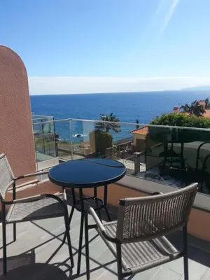 a table and chairs on a balcony with the ocean at Ventur Flat in Caniço