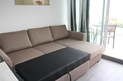 a brown couch in a living room with a balcony at Ventur Flat in Caniço