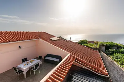 a balcony with a table and a view of the ocean at Apartamento Celia in Arco da Calheta
