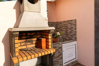 an outdoor brick oven in the side of a house at Apartamento Celia in Arco da Calheta