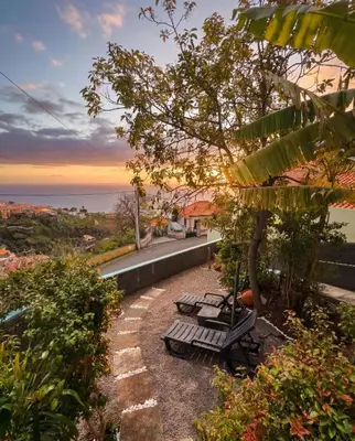 a bedroom with a twin bed and a chair at Granny House Madeira in Funchal