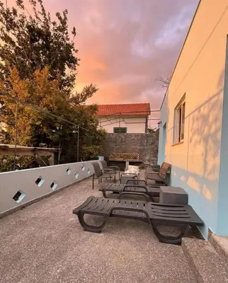a view of a garden from a porch with a bench at Granny House Madeira in Funchal