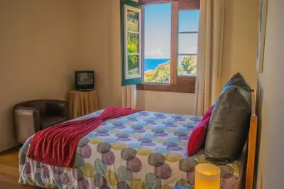 a bedroom with a bed with a view of the ocean at Villa Ricardo in Porto da Cruz
