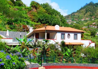 a small white house in front of a mountain at Villa Ricardo in Porto da Cruz