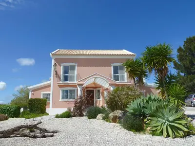 a pink house with palm trees in front of it at Highview Villa in Lagos