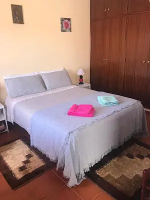 a bedroom with a bed with pink towels on it at Casa Da Estela in Carrapateira