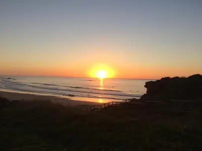 a sunset on the beach with the sun setting at Casa Da Estela in Carrapateira