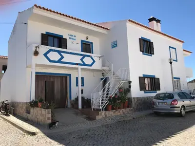 a white house with a car parked in front of it at Casa Da Estela in Carrapateira