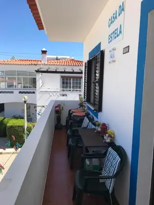 a balcony of a restaurant with tables and chairs at Casa Da Estela in Carrapateira