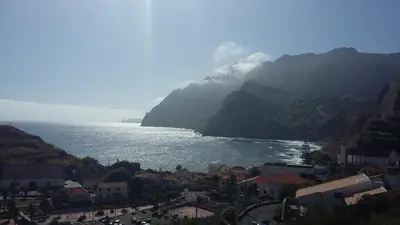 a large body of water next to a mountain at Casa Shalom in Faial