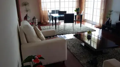 a living room with a white couch and a table at Casa Shalom in Faial
