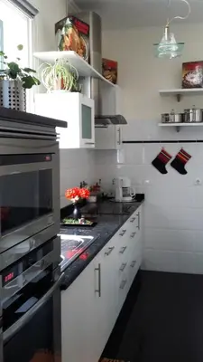 a kitchen with white cabinets and a black counter top at Casa Shalom in Faial