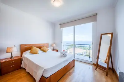 a bedroom with a bed and a large window at Villa São Tiago by Amazing Madeira in Funchal