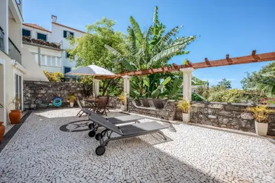 a patio with a table and an umbrella at Villa São Tiago by Amazing Madeira in Funchal
