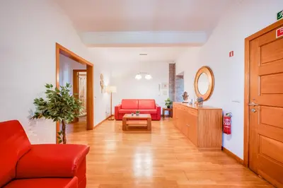 a living room with a red couch and a table at Villa São Tiago by Amazing Madeira in Funchal