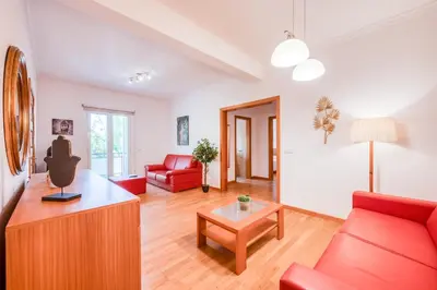 a living room with a red couch and a table at Villa São Tiago by Amazing Madeira in Funchal