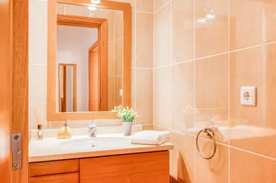 a bathroom with a sink and a mirror and a shower at Villa São Tiago by Amazing Madeira in Funchal