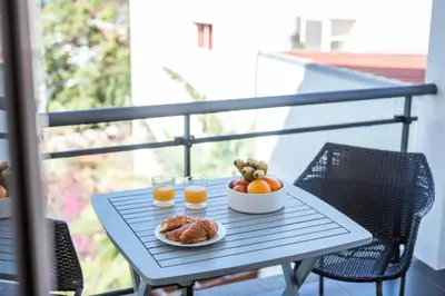a table with a bowl of fruit and two glasses of orange juice at Villa São Tiago by Amazing Madeira in Funchal