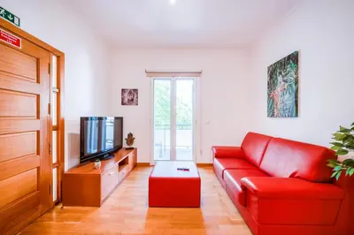 a living room with a red couch and a tv at Villa São Tiago by Amazing Madeira in Funchal