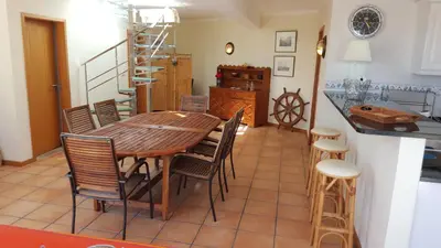 a kitchen and dining room with a wooden table and chairs at Sotavento Guest House in Porto Santo