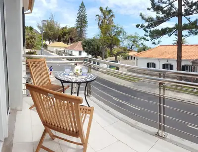 a table and chairs on a balcony with a view of a street at Sotavento Guest House in Porto Santo
