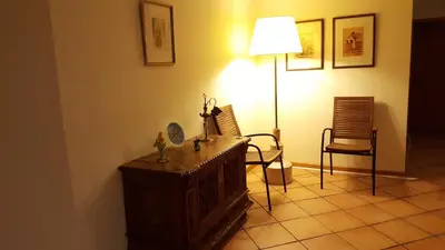 a room with a table and two chairs and a lamp at Sotavento Guest House in Porto Santo