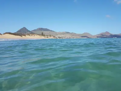 a body of water with a beach in the background at Sotavento Guest House in Porto Santo