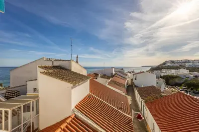 a view of the roofs of buildings and the ocean at Casa Da Paz in Salema