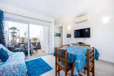 a living room with a dining room table and a television at Casa Da Paz in Salema