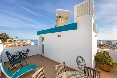 a balcony with chairs and a water heater on a building at Casa Da Paz in Salema