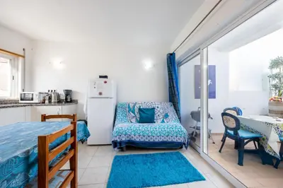 a kitchen with a refrigerator and a chair in a room at Casa Da Paz in Salema