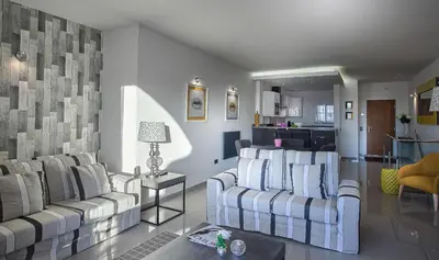 a living room with two couches and a kitchen at Waterside Village in Luz