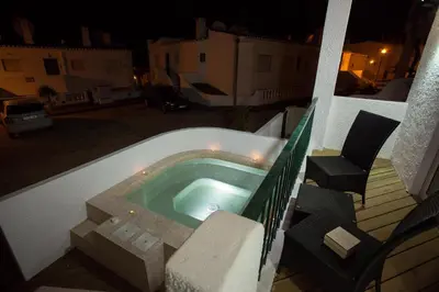 a small swimming pool on a balcony at night at Waterside Village in Luz