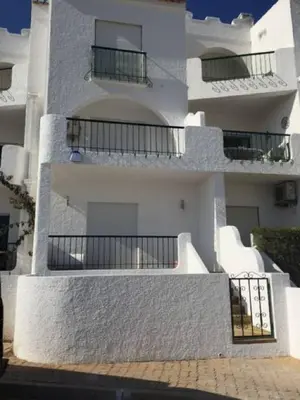 a white building with balconies on the side of it at Waterside Village in Luz