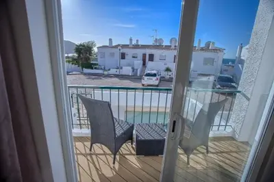 a balcony with two chairs and a table on a porch at Waterside Village in Luz