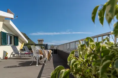a balcony with chairs and a view of the ocean at Apartamento Teixeira in Arco da Calheta
