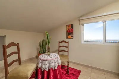 a room with a table and chairs and a window at Apartamento Teixeira in Arco da Calheta