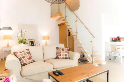 a living room with a white couch and stairs at Cercas Velhas in Sagres