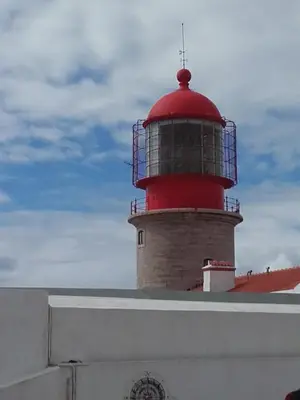 a red lighthouse sitting on top of a building at Cercas Velhas in Sagres