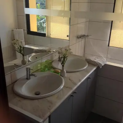 a bathroom with two sinks and a mirror at Fazenda do Sousinha in Funchal