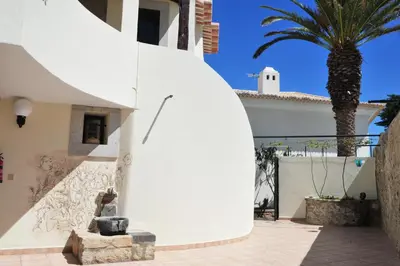 a building with a statue next to a palm tree at 16 Porto Santo Apartments in Porto Santo