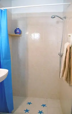a bathroom with a shower with blue stars on the floor at 16 Porto Santo Apartments in Porto Santo
