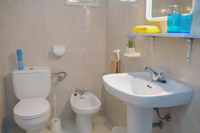 a bathroom with a white toilet and a sink at 16 Porto Santo Apartments in Porto Santo