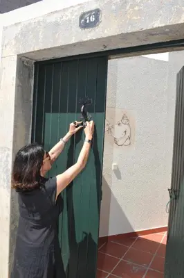 a woman taking a picture of a green door at 16 Porto Santo Apartments in Porto Santo