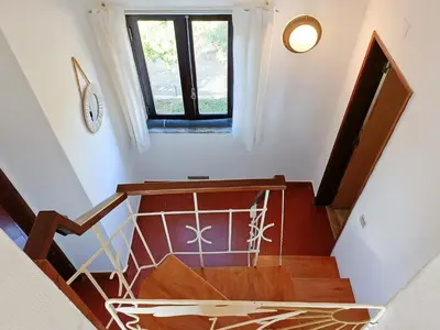 a staircase in a house with a window at Casa dos Pinheiros in Praia da Arrifana