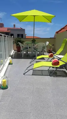 a patio with a table and a yellow umbrella at Casa Violeta in Funchal