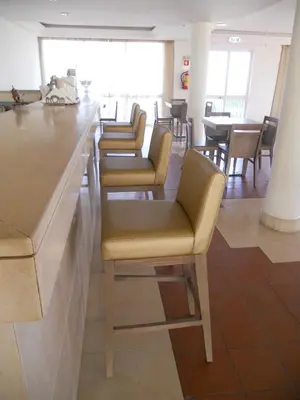 a row of chairs at a bar in a restaurant at INATEL Porto Santo in Porto Santo